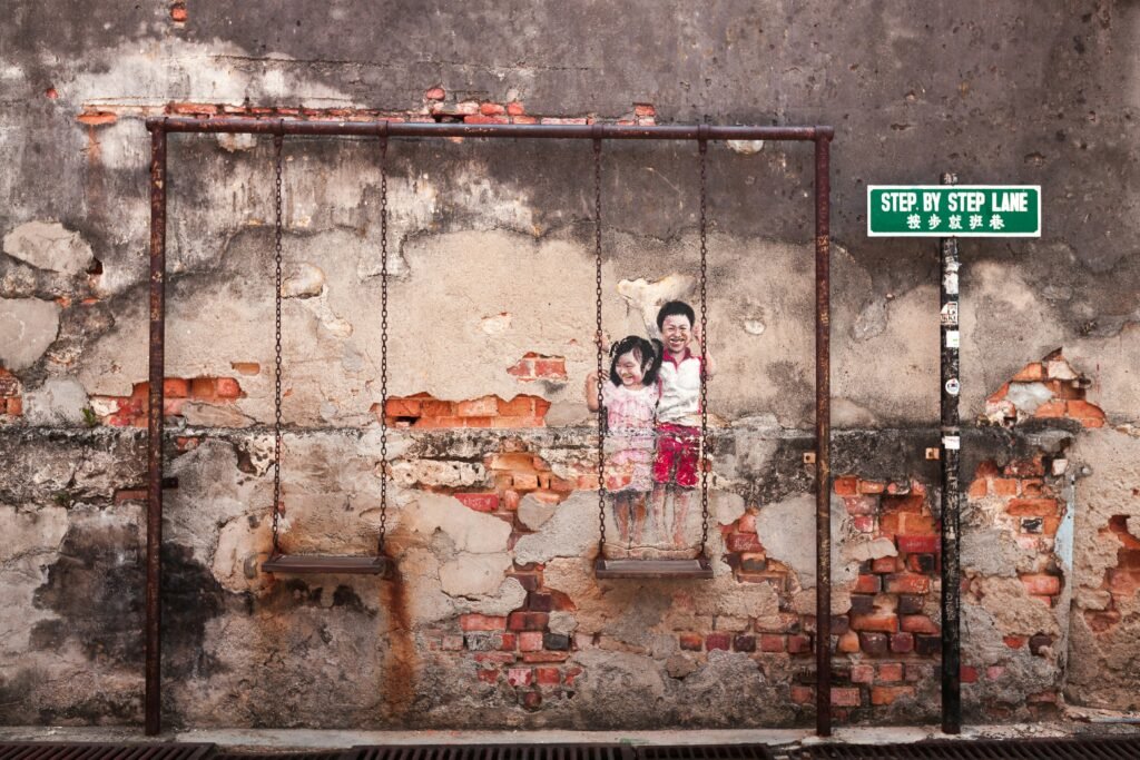 The murals of George Town are among Penang’s most famous attractions. Scattered throughout the heritage streets, these interactive street artworks blend history, culture, and everyday life. Many iconic pieces were created by Lithuanian artist Ernest Zacharevic, including the well-known “Children on a Bicycle.” Exploring the murals is a popular activity, turning the old town into an open-air art gallery and perfect photo spot for visitors.