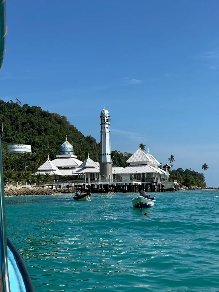 The Floating Mosque on Pulau Perhentian Kecil, officially known as Masjid Al‑Rahman Perhentian, is a small mosque built on pillars above the sea. It is located near the main jetty of the Perhentian Islands in Malaysia. The mosque is known for its peaceful setting and beautiful ocean views. Visitors often stop here to admire the architecture, take photos, or enjoy the calm atmosphere. For Muslim travelers, it is also an important place for daily prayers while visiting the Perhentian Islands.